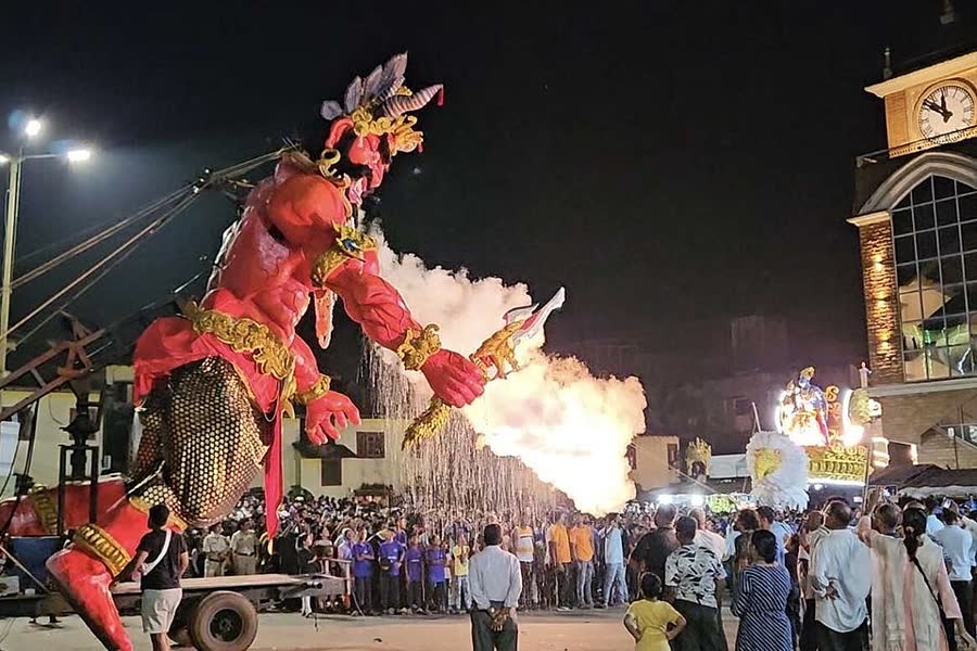 A huge painted effigy of the demon Narakasura on a street in Goa, with smoke and lights