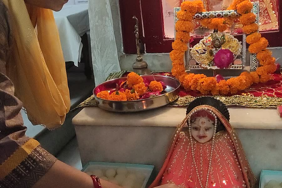 Women arranging food offerings before decorated deities for Annakut puja