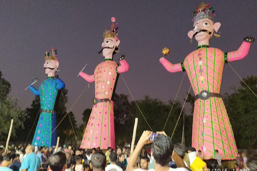 Tall effigies of Ravana, Kumbhakarna and Meghnad stand against a twilight sky before being burned in Delhi