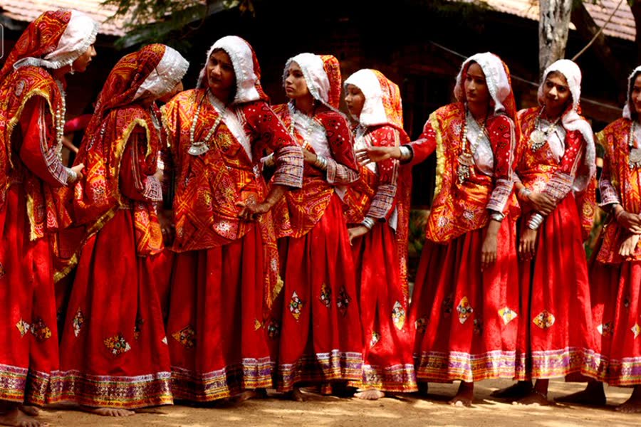 Women in red traditional dress dancing Garba during Navratri
